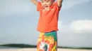 Bermain di pantai, Cipung mengenakan outfit colorful. Ia mengenakan atasan kaus oranye dengan celana panjang tie-dye yang bernuansa senada. Foto: Instagram.