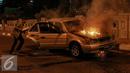 Pemilik mobil berusaha menyelamatkan barang miliknya saat mobil terbakar di jalan layang Latuharhari, Jakarta, Kamis (18/9/2015). Diduga kebakaran akibat konsleting listrik yang terjadi dibagian depan kap mobil. (Liputan6.com/Faizal Fanani)