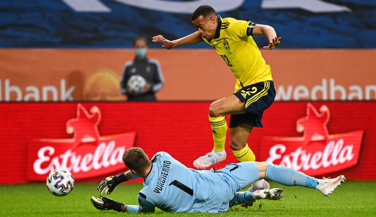 Pemain Swedia Robin Quaison bersaing dengan kiper Armenia David Yurchenko pada pertandingan persahabatan jelang Euro 2020 di Solna, Swedia, Sabtu (5/6/2021). Swedia menang 3-1. (Jonathan NACKSTRAND/AFP)