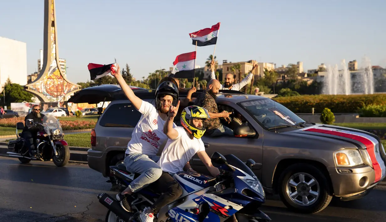 Pendukung Presiden Suriah Bashar Assad mengibarkan bendera Suriah pada pertemuan di Omayyid Square, Damaskus, Suriah, Minggu (23/5/2021). Pemilihan presiden di negara yang dilanda perang itu akan diadakan pada 26 Mei. (AP Photo/Hassan Ammar)