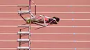 Atlet asal Trinidad dan Tobago, Deborah John tertelungkup setelah terjatuh saat melewati rintangan kelima dalam cabang lari halang rintang 100 meter putri Kejuaraan Atletik Dunia yang digelar di Stadion London, Inggris (11/8). (AFP PHOTO/Glyn KIRK)