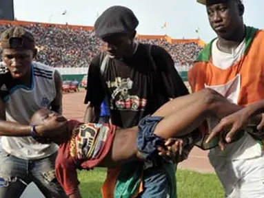 Supporters carry a lifeless body  on March 29, 2009 at Felix Houphouet-Boigny stadium in Abidjan during the World Cup 2010 and African Cup of Nations qualification match between Ivory Coast and Malawi. AFP PHOTO/ISSOUF SANOGO
