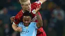 Pemain Manchester City, Raheem Sterling dan pemain Bristol City, Milan Duric berebut bola pada leg pertama semifinal Piala Liga Inggris di Stadion Etihad, Selasa (9/1). Man City menang 2-1 berkat gol telat Sergio Aguero di injury time. (AP/Dave Thompson)