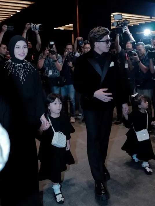 Aurel Hermansyah hadir bersama suami dan anak-anaknya. Aurel pun dibalut long dress hitam dihiasi beads dipadukan kerudung warna senada. Atta juga mengenakan jas hitam serasi dengan kemejanya. [@attahalilintar]