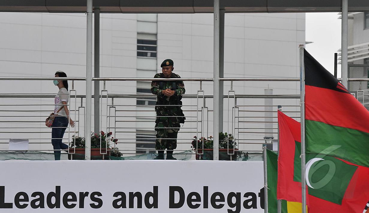 Seorang aparat keamanan terlihat berjaga di jembatan penyeberangan orang (JPO) kawasan Bundaran HI, Jakarta, Sabtu (18/4/2015). Sterilisasi dilakukan di tempat-tempat umum yang dilalui peserta Konferensi Asia Afrika (KAA). (Liputan6.com/Johan Tallo)