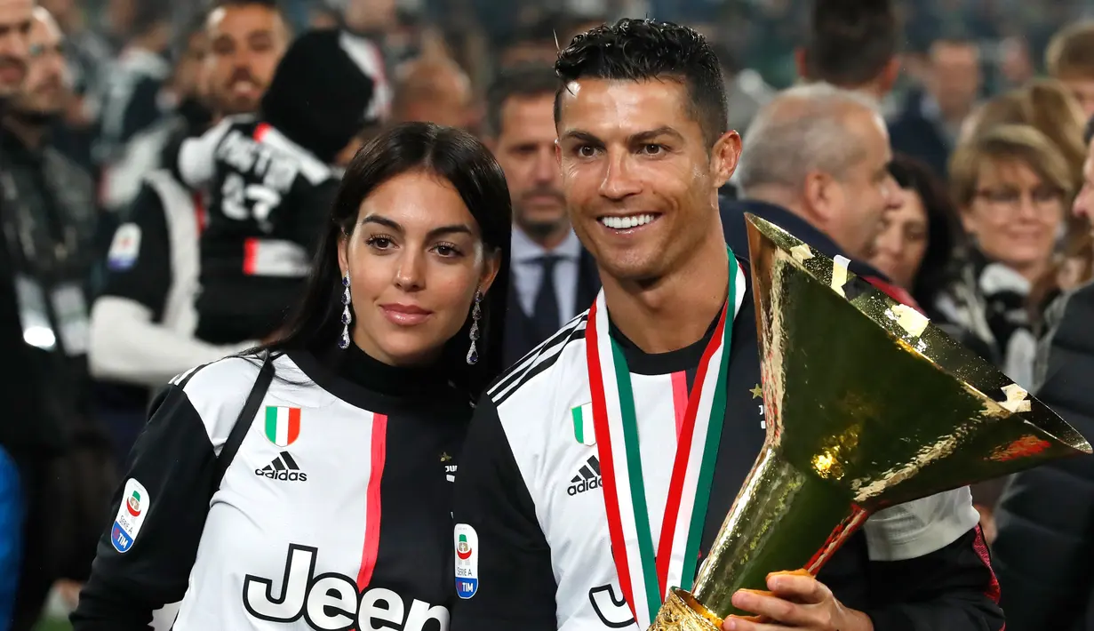 Striker Juventus, Cristiano Ronaldo bersama kekasihnya Georgina Rodriguez berpose bersama Piala Liga Italia Serie A usai menjuarainya untuk ke-33 kalinya di Stadion Allianz, Turin (19/5/2019). (AP Photo/Antonio Calanni)
