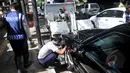Petugas Dishub memasang alat derek pada kendaraan yang parkir liar di kawasan Cikini, Jakarta, Selasa (28/4/2015). Masih banyak mobil pribadi yang parkir disembarang tempat.(Liputan6.com/JohanTallo)
