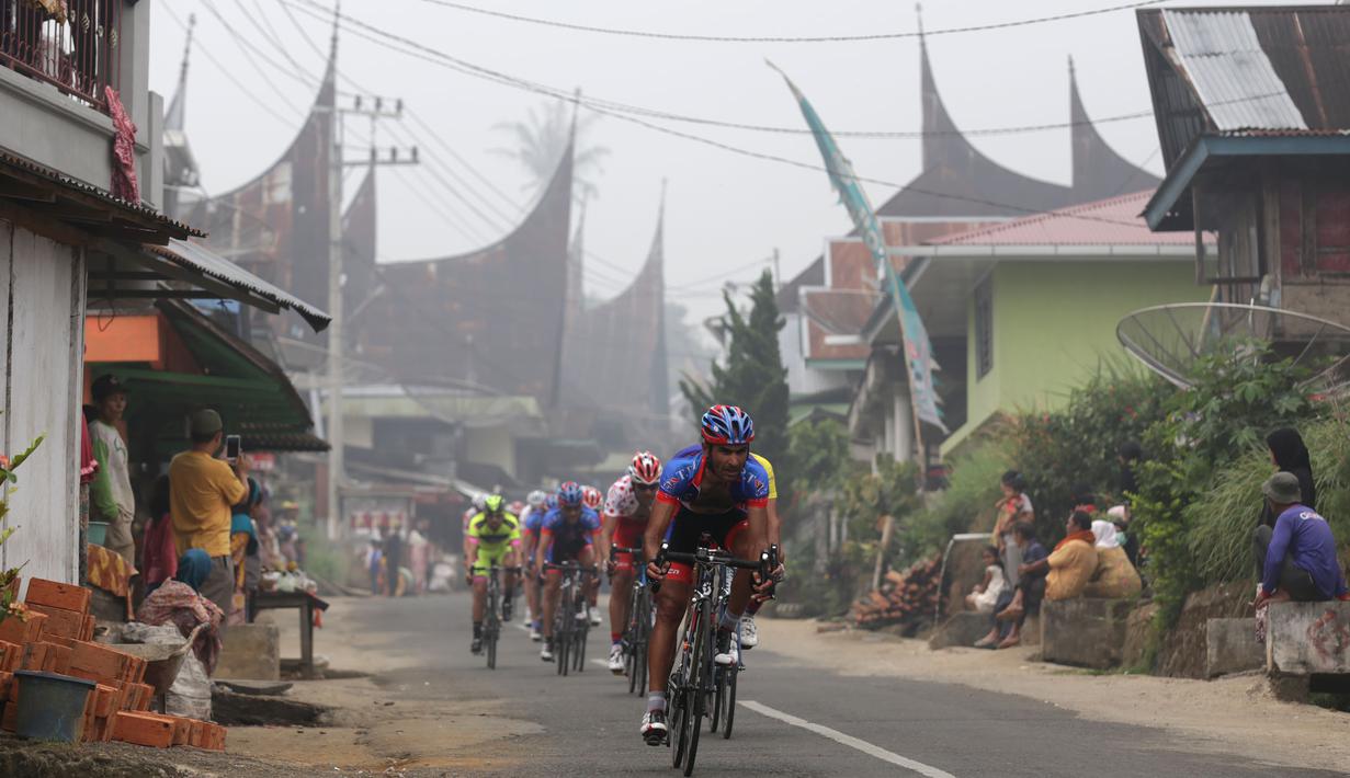 Para pebalap melaju kencang di sebuah turunan di perkampungan Baruh Bukit, Kab. Tanah Datar dalam Etape 5 Tour de Singkarak 2015, Rabu (7/10/2015). (Bola.com/Arief Bagus)