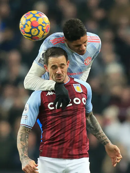 Bek Manchester United, Raphael Varane berebut bola dengan striker Aston Villa, Danny Ings pada pertandingan lanjutan Liga Inggris di Villa Park di Birmingham, Inggris, Minggu (16/1/2022). Aston Villa kini berada di posisi ke-13 dengan 23 poin. (AP Photo/Rui Vieira)