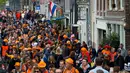 Orang-orang mengenakan atribut dan pakaian oranye mendominasi jalan pada Hari Ulang Tahun Raja atau King's Day di Amsterdam, Belanda, 27 April 2018. Di hari ini, jalanan dipenuhi dengan pesta yang meriah, serta banyak pasar-pasar unik. (AP/Peter Dejong)