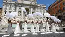 Para perempuan yang upacara pernnikahannya ditunda atau dibatalkan akibat pandemi covid-19 melakukan protes di Trevi Fountain, Roma, Selasa (7/7/2020). Mereka memprotes kebijakan pemerintah Italia yang masih melarang adanya acara pernikahan, meski lockdown sudah dilonggarkan. (AP/Riccardo De Luca)