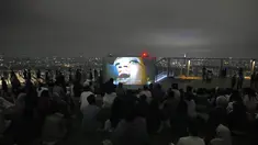 Pengunjung menonton film di rooftop dek observasi Shibuya Sky di Tokyo, Sabtu (9/10/2021). seminggu setelah Jepang sepenuhnya keluar dari keadaan darurat virus corona untuk pertama kalinya dalam lebih dari enam bulan. (AP Photo / Kiichiro Sato)