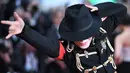 Pria berpenampilan Michael Jackson berpose setibanya di karpet merah  pemutaran film Solo: A Star Wars Story pada Festival Film Cannes, Prancis, Selasa (15/5). Kehadiran pria mirip mendiang raja musik pop dunia itu mengundang perhatian. (AFP/LOIC VENANCE)