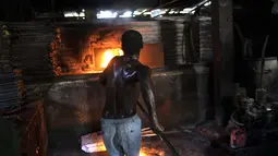 Seorang pria menyalakan oven kayu untuk membuat roti di toko roti Bongu di lingkungan Bel Air di Port-au-Prince, Haiti, Senin (27/9/2021).  (AP Photo/Rodrigo Abd)
