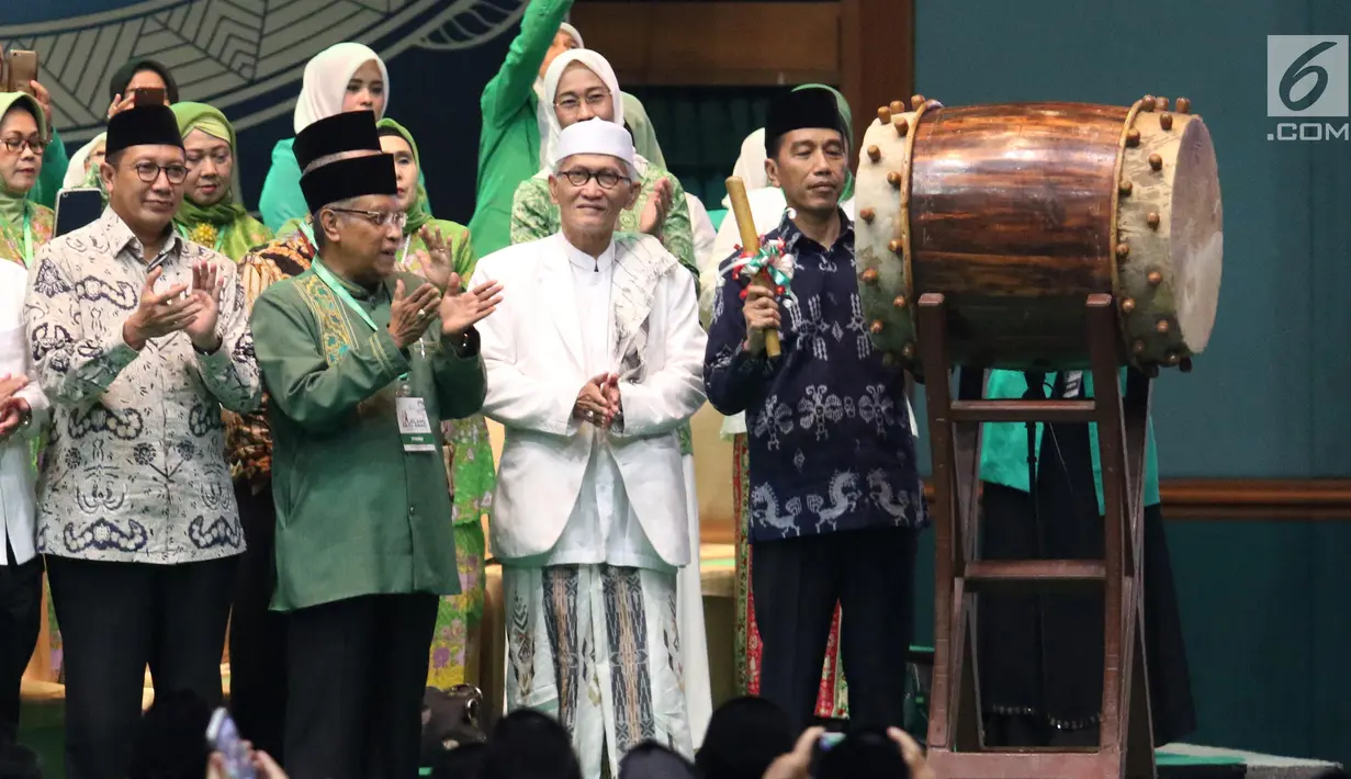 Presiden Joko Widodo atau Jokowi memukul bedug saat membuka Harlah ke-93 NU di Jakarta, Kamis (31/1). Jokowi didampingi sejumlah menteri Kabinet Kerja saat menghadiri Harlah ke-93 NU. (Liputan6.com/Angga Yuniar)