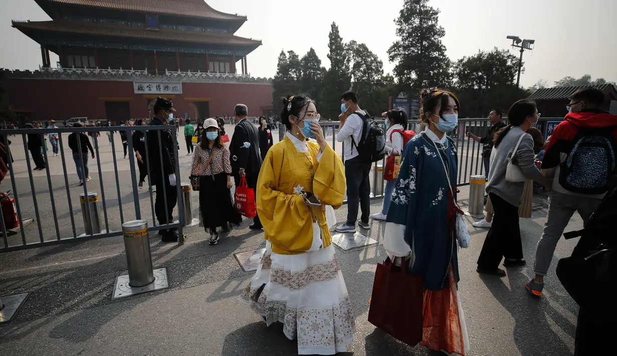 Wanita mengenakan kostum tradisional keluar dari Kota Terlarang selama di Beijing (7/10/2020). Liburan tahun ini, yang bertepatan dengan Festival Pertengahan Musim Gugur, akan menjadi ujian lakmus apakah industri pariwisata China dapat bangkit kembali setelah digempur COVID-19. (AP Photo/Andy Wong)