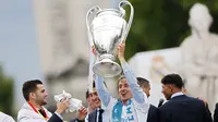 Gelandang Real Madrid, Luka Modric, mengangkat trofi Liga Champions di Monumen Cibeles, Madrid, Minggu (27/5/2018). Real Madrid menggelar pawai kemenangan bersama fans usai menjuarai Liga Champions 2018. (AP/Francisco Seco)