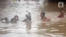 Anak-anak berenang di salah satu gang di Kawasan Rawajati yang tergenang banjir, Jakarta, Rabu Rabu (1/1/2020). Hujan yang mengguyur Jakarta sejak Selasa sore (31/12/2019) mengakibatkan banjir di sejumlah titik di Jakarta. (Liputan6.com/Helmi Fithriansyah)