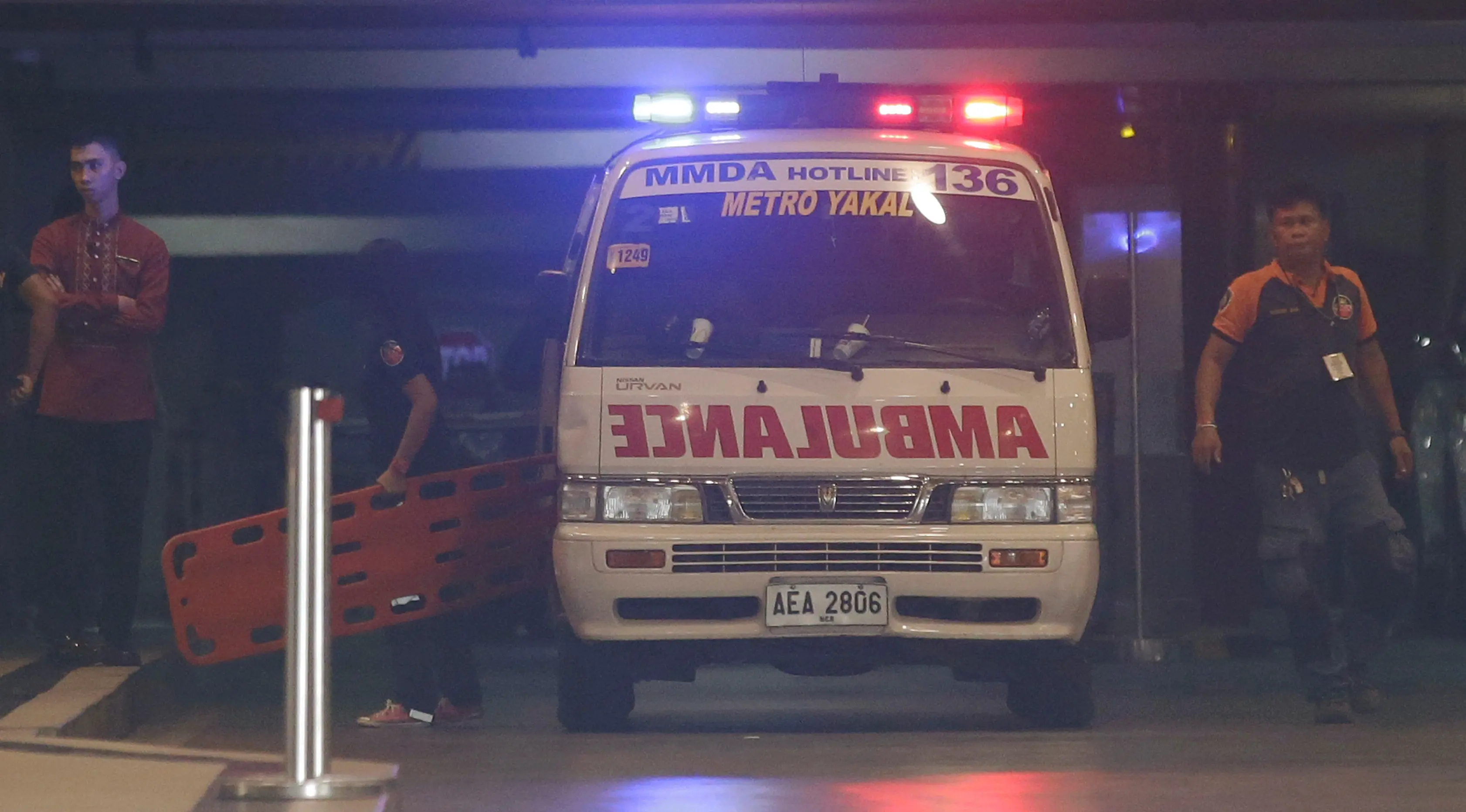 Petugas medis membawa tandu masuk ke dalam area hotel di kompleks Resorts World Manila, Filipina, Jumat (2/6). Seorang pria bersenjata ditemukan bunuh diri usai menyerang ruang kasino dengan beberapa kali tembakan. (AP Photo/Aaron Favila)