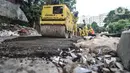 Petugas Sudin Bina Marga Jakarta Pusat memperbaiki jalan ambles di Jalan Inspeksi Kali Ciliwung, Kenari, Rabu (19/1/2022). Jalan yang berada di belakang RSCM tersebut ambles sepanjang 40 meter akibat terkikis oleh hujan deras kemarin sehingga menyulitkan akses warga. (merdeka.com/Iqbal S Nugroho)