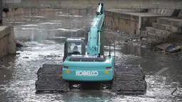 Sebuah ekskavator dikerahkan Pemprov DKI untuk mengeruk lumpur di kali inspeksi Ciliwung, Jakarta, Selasa (3/3/2015). Pengerukan dilakukan untuk menjaga sungai tetap baik dan lancar. (Liputan6.com/Faizal Fanani)