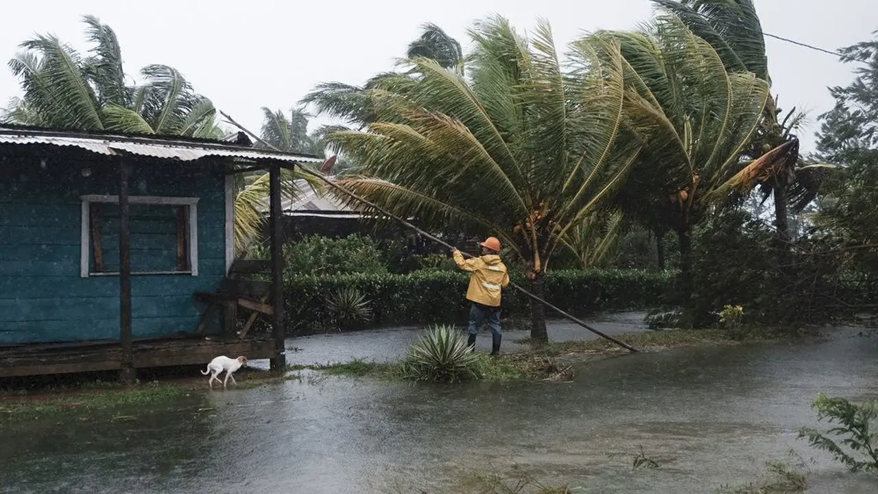Seorang pria sedang memperbaiki atap rumah yang terkena air banjir akibat Badai Eta di Wawa, Nikaragua, pada Selasa (3/11/2020). (AP Photo/Carlos Herrera)