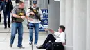 Petugas kepolisian berbincang dengan penumpang saat terjadi penembakan di Bandara Fort Lauderdale, Florida, AS (6/1). Ratusan orang dilaporkan berada di sekitar lokasi saat penembakan terjadi. (AP Photo/Wilfredo Lee)