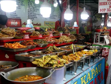 Warga memilih menu makanan khas Sumatera Barat yang dijajakan di kawasan Food Street Kramat, Jakarta, Jumat (30/4/2021). Kawasan yang menjual beragam menu makanan khas Sumatera Barat selalu ramai dikunjungi pecinta kuliner terutama jelang waktu berbuka puasa. (Liputan6.com/Helmi Fithriansyah)