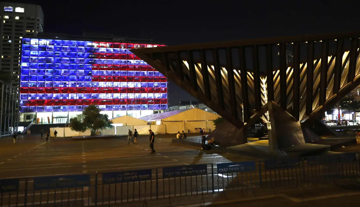 Suasana di dekat balai kota Tel Aviv yang dihiasi warna bendera AS untuk menghormati korban penembakan brutal di Las Vegas di Rabin Square, Tel Aviv (2/10). Menurut laporan, pelaku Stephen Paddock bunuh diri di lokasi kejadian. (AFP Photo/Jack Guez)