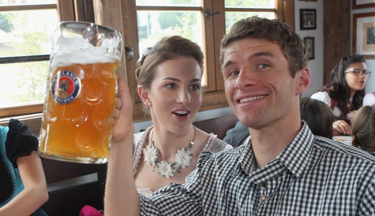 Thomas Mueller dan istrinya Lisa saat ikut Oktoberfest, Jerman, Minggu (5/10/2014) (AFP PHOTO/ALEXANDER HASSENSTEIN)