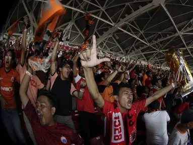 Suporter Persija Jakarta mengangkat replika piala saat merayakan gelar juara Liga 1 di SUGBK, Jakarta, Minggu (09/12). Persija menang 2-1 atas Mitra Kukar. (Bola.com/M Iqbal Ichsan)