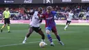 Gelandang Barcelona, Frenkie de Jong berebut bola dengan pemain Valencia, Dimitri Foulquier pada pertandingan La Liga Spanyol di stadion Mestalla, Spanyol, Minggu (20/2/2022). Barcelona menang atas Valencia 4-2. (AP Photo/Alberto Saiz)