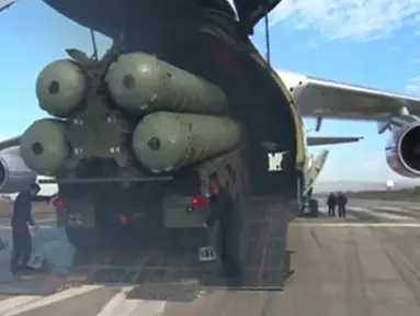 Sebuah potongan rekaman video dari Departemen Pertahanan Rusia pada (26/11). Sistem rudal pertahanan udara S-400 Rusia dikeluarkan dari pesawat cargo saat tiba di pangkalan udara Hmeymim di Suriah. (Reuters/ Departemen Pertahanan Federasi Rusia)