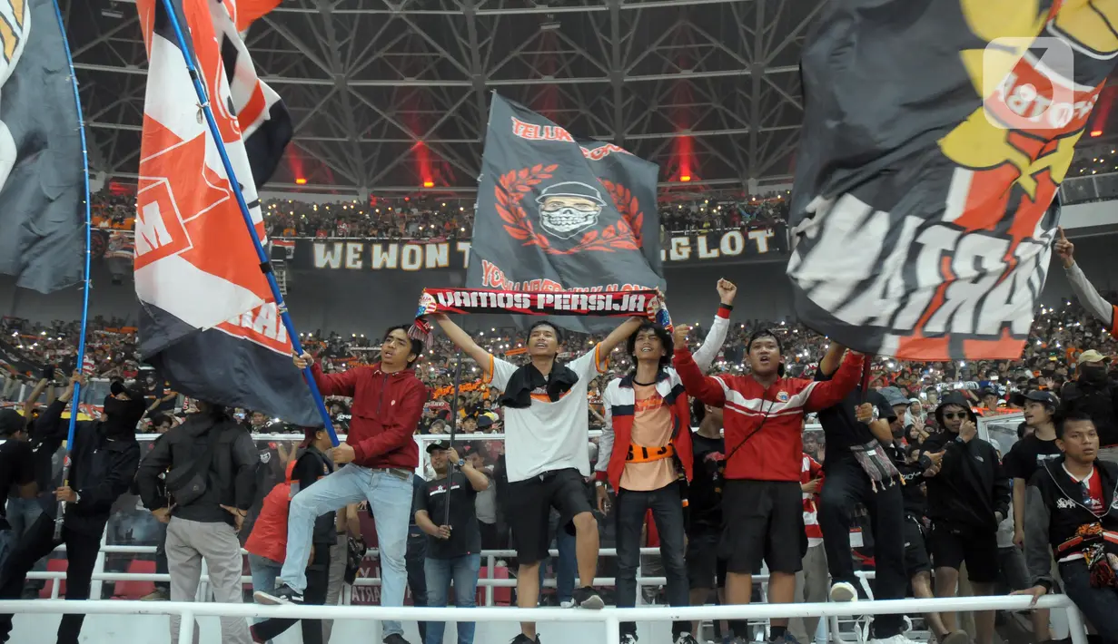 Suporter Persija mengibarkan bendera saat merayakan HUT ke-91 Persija dan kemenangan atas Persipura di laga lanjutan Shopee Liga 1 Indonesia 2019 di Stadion Utama Gelora Bung Karno, Jakarta, Kamis (28/11/2019). Persija unggul 1-0. (Liputan6.com/Helmi Fithriansyah)