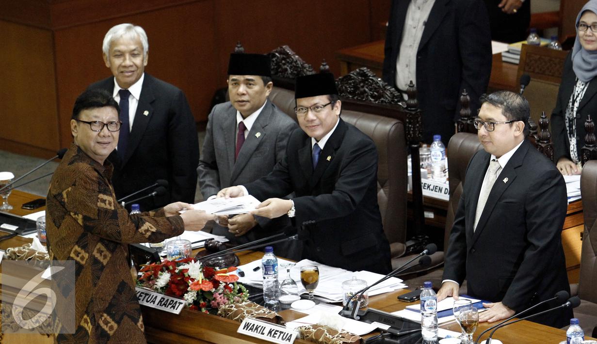 Menteri Dalam Negeri Tjahjo Kumolo menyerahkan hasil pandangannya terkait pengesahan Revisi UU tentang Pilkada keada Ketua Sidang Taufik Kurniawan disaksikan Ketua DPR Ade Komarudin (kedua kanan), Jakarta, Kamis (2/6/2016). (Liputan6.com/Johan Tallo)