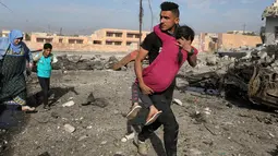 Tentara pasukan khusus Irak berjalan sambil menggendong seorang gadis yang terluka menyusul serangan bom mobil bunuh diri yang dilakukan militan ISIS di kota Tahrir, Irak, 17 November 2016. (REUTERS/Goran Tomasevic)