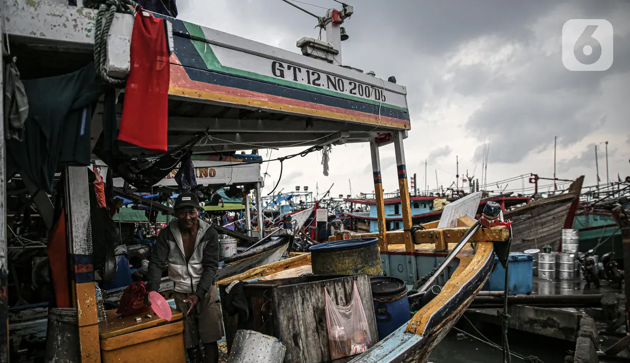 Nelayan beraktivitas di perahu saat bersandar di Pelabuhan Muara Angke, Jakarta, Senin (26/12/2022). Akibat angin  barat dan gelombang tinggi menyebabkan nelayan tradisional di Muara Angke libur melaut. (Liputan6.com/Faizal Fanani)
