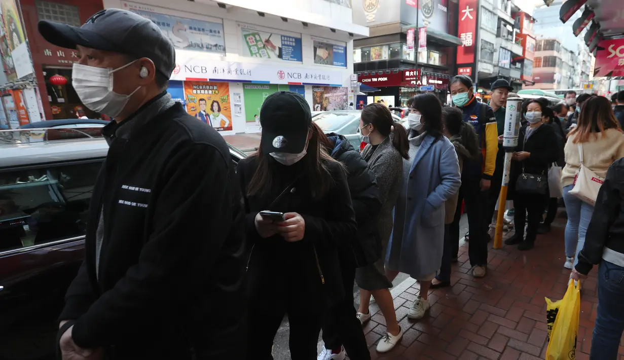 Warga mengantre untuk mendapatkan masker wajah gratis di luar sebuah toko di Tsuen Wan, Hong Kong, Selasa (28/1/2020). Hong Kong terkonfirmasi memiliki delapan kasus infeksi virus corona. (AP Photo/Achmad Ibrahim)