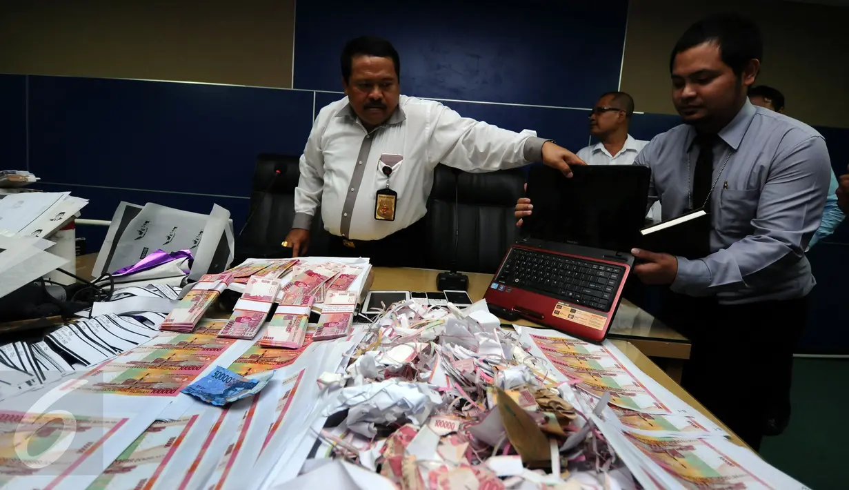 Petugas memperlihatkan sejumlah barang bukti saat rilis pengungkapan uang palsu di Bareskrim Mabes Polri, Gedung KKP, Jakarta, Senin (10/10). Peredaran dikendalikan dari rutan, empat tersangka diamankan dalam kasus ini. (Liputan6.com/Helmi Fithriansyah)