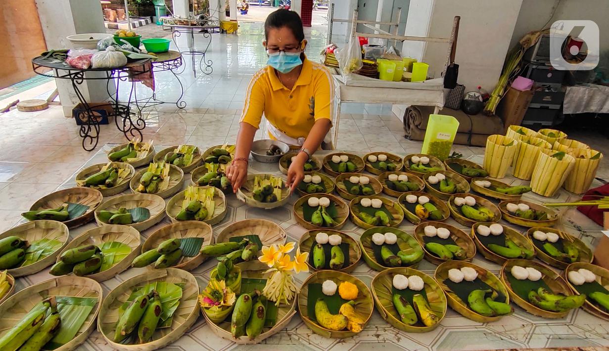Seorang umat Hindu menyiapkan Ajuman untuk persembahan di Pura Kerta Jaya, Kota Tangerang, Banten, Selasa (15/9/2020). Persiapan tersebut dilakukan jelang Hari Raya Galungan yang jatuh pada 16 September 2020. (Liputan6.com/Angga Yuniar)