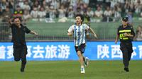 Seorang penyusup lapangan berlari menghindari kejaran petugas pada laga persahabatan antara Argentina melawan Australia di Workers' Stadium, Beijing, Kamis (15/06/2023). (AP Photo/Mark Schiefelbein)