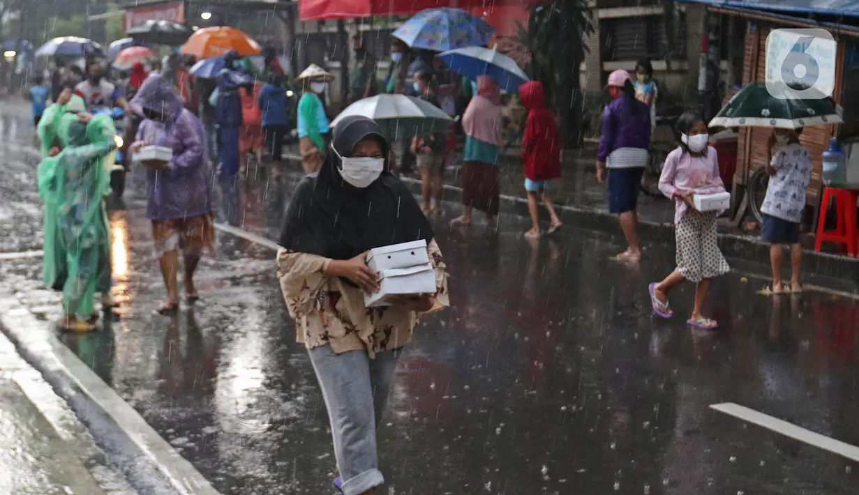 Warga membawa takjil gratis yang dibagikan di Jalan Cempaka Putih Tengah XXI, Jakarta, Rabu (14/4/2021). Pembagian takjil gratis ini dilakukan dengan menerapkan protokol kesehatan ketat. (Liputan6.com/Herman Zakharia)