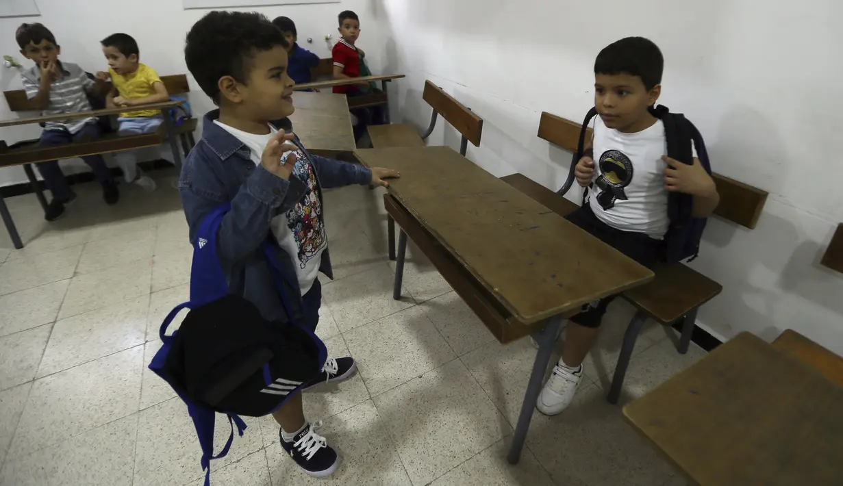 Anak-anak sekolah tiba di ruang kelas mereka di sekolah swasta Birkhadem, di luar Aljazair, Rabu (21/9/2022). Partai dan asosiasi Aljazair, dalam beberapa tahun terakhir, menyerukan agar pelajaran bahasa Inggris dimasukkan ke dalam kurikulum sekolah dasar karena bahasa tersebut paling banyak digunakan di kalangan ilmiah secara global. (AP Photo/Fateh Guidoum)