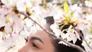 Rambutnya ditata rapi dalam gaya sanggul simpel namun berkelas, mempertegas fitur wajahnya yang lembut namun kuat.   [@arieltatum].