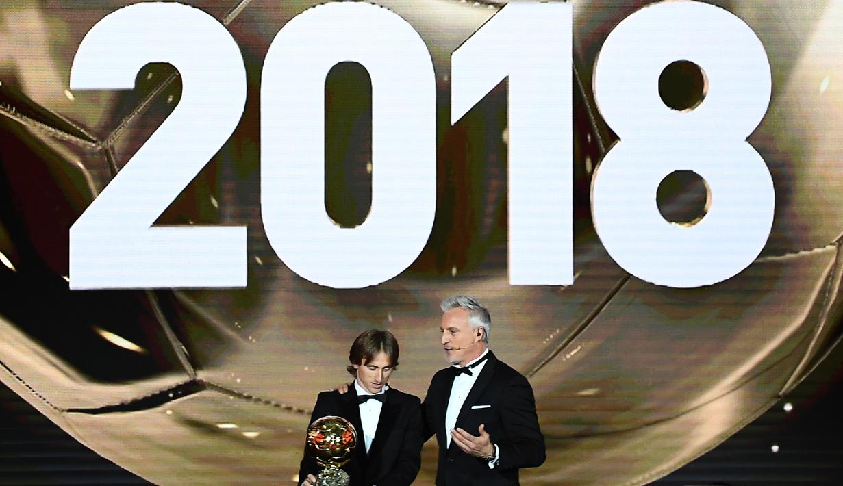 Gelandang Real Madrid asal Kroasia, Luka Modric, bersama legenda David Ginola saat malam penghargaan Ballon d'Or di Paris, Senin (3/12). Dirinya berhasil meraih gelar Ballon d'Or. (AFP/Franck Fife)