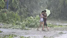 Beberapa warga mencoba melintas ditengah Topan Kalmaegi yang menerjang wilayah Qionghai di provinsi Hainan, Tiongkok, (16/9/2014). (REUTERS/Stringer)