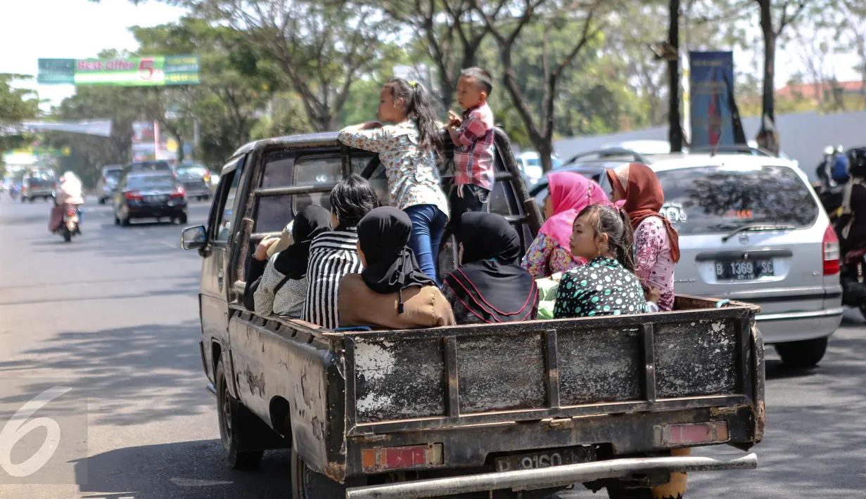 Kendaraan bak terbuka berisi warga melintasi jalan Ibukota Jakarta, Minggu (19/7/2015). Meskipun membahayakan, mobil pick up menjadi pilihan warga untuk bersilaturahmi saat momen Lebaran. (Liputan6.com/Faizal Fanani)
