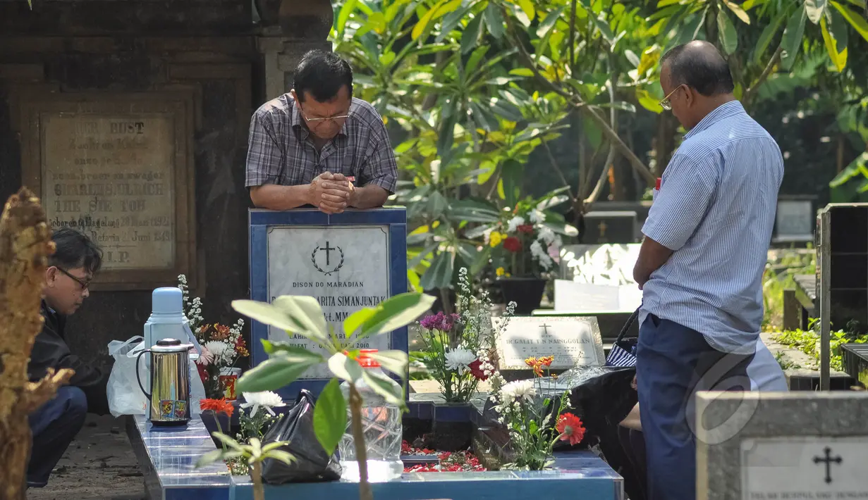 Selain merayakan Hari Kebangkitan Yesus Kristus atau Paskah di gereja-gereja, umat Kristiani juga melakukan ziarah ke makam keluarga yang telah meninggal dunia di Menteng Pulo, Jakarta, Minggu (5/4/2015). (Liputan6.com/Faizal Fanani)