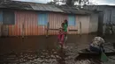 Seorang ibu membawa putrinya menuju sekolah di jalan yang tergenang banjir oleh naiknya sungai Negro di Iranduba, negara bagian Amazonas, Brasil, Senin (23/5/2022). Wilayah Amazon sedang dilanda banjir dengan 35 kotamadya yang menghadapi salah satu banjir terburuk mereka dalam beberapa tahun dan permukaan air diperkirakan akan meningkat selama beberapa bulan mendatang. (AP Photo/Edmar Barros)