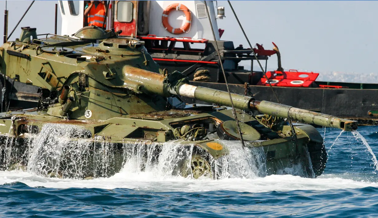 Aktivis lingkungan menenggelamkan sebuah tank lama ke dasar Laut Mediterania di lepas pantai kota pelabuhan Sidon, Lebanon, Sabtu (28/7). Penenggelaman ini diharapkan bisa menciptakan surga baru bagi satwa liar di Laut Mediterania. (AFP / Mahmoud ZAYYAT)